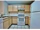 Efficient kitchen with white appliances and wood cabinets at 831 Camargo Way # 203, Altamonte Springs, FL 32714