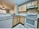 Modern kitchen with white appliances and wood cabinets at 831 Camargo Way # 203, Altamonte Springs, FL 32714