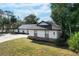 Stunning white house with dark gray roof, stone accents, and a lush green lawn at 104 Crestwood Dr, Longwood, FL 32779