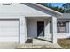Front entrance with black door and white garage door at 1073 Humphrey Blvd, Deltona, FL 32738
