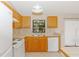 Kitchen with light wood cabinets, white appliances, and tile at 1073 Humphrey Blvd, Deltona, FL 32738