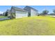 Large grassy backyard with a view of the house and garage at 12285 Joshua Tree Trl, Windermere, FL 34786