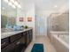 Elegant bathroom with granite countertops, a soaking tub, and walk-in shower at 1230 Aloha Blvd, Davenport, FL 33897