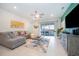 Bright living room features L-shaped sofa and large flat-screen TV at 1230 Aloha Blvd, Davenport, FL 33897