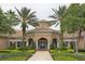 Community clubhouse entrance with palm trees and landscaping at 1300 Gilford Point Ln # 1300, Davenport, FL 33896