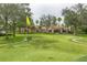 Community putting green with palm trees and clubhouse in background at 1300 Gilford Point Ln # 1300, Davenport, FL 33896