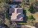 An aerial view of a home with a tile roof, surrounded by trees and a landscaped yard at 25629 Hawks Run Ln, Sorrento, FL 32776