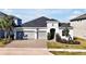 Attractive two-story house with gray siding, three-car garage, and landscaped yard at 3359 Hanging Tide St, Winter Garden, FL 34787
