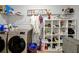 Laundry room with washer, dryer, and ample storage shelving at 3359 Hanging Tide St, Winter Garden, FL 34787