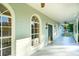 Inviting front porch with white railings, arched windows, and a dark green front door at 4942 Simmons Rd, Orlando, FL 32812