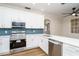 Modern kitchen with white cabinets, stainless steel appliances, and blue tile backsplash at 4942 Simmons Rd, Orlando, FL 32812