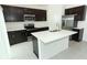 Modern kitchen with dark cabinets, stainless steel appliances, and an island at 5021 Bougainvillea Ct, Lake Hamilton, FL 33851