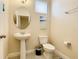 Clean and updated bathroom with pedestal sink, toilet, and oval mirror at 5303 Wildwood Way, Davenport, FL 33837