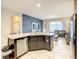 Open concept kitchen with island, stainless steel appliances and view to living room at 5303 Wildwood Way, Davenport, FL 33837