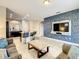 Open concept living room with kitchen access, comfortable seating, and a large TV at 5303 Wildwood Way, Davenport, FL 33837