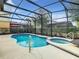 Relaxing kidney-shaped pool and spa with screened enclosure at 5303 Wildwood Way, Davenport, FL 33837