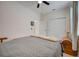 Bedroom with gray comforter, ceiling fan, and double doors leading to a bathroom at 541 Cantabria Dr, Davenport, FL 33837