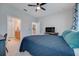 Bright bedroom with a blue comforter, ceiling fan, and ensuite bathroom access at 541 Cantabria Dr, Davenport, FL 33837