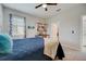 Bedroom with a blue comforter, ceiling fan, and built-in shelving at 541 Cantabria Dr, Davenport, FL 33837