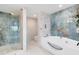 Elegant bathroom with a soaking tub, walk-in shower, and marble tile at 7593 Gathering Dr # 802, Reunion, FL 34747