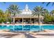 Resort-style pool with cabana and surrounding lounge chairs at 7593 Gathering Dr # 802, Reunion, FL 34747