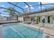 Inviting screened-in pool with lounge area and lush greenery at 1010 Chance Cv, Oviedo, FL 32765