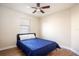 Bright bedroom with blue bedding, wood-look floors, and ceiling fan at 111 Windy Dune Ct, Kissimmee, FL 34743