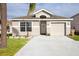 Charming single-story home with a welcoming front yard and attached garage at 111 Windy Dune Ct, Kissimmee, FL 34743