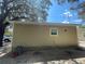 Rear view of tan house with a trash can and yard at 1170 S Central Ave, Apopka, FL 32703