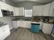 Kitchen with white cabinets, granite countertops, and teal dishwasher at 1170 S Central Ave, Apopka, FL 32703