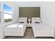 Bright bedroom with two twin beds, a large window, and an accent wall at 159 Golden Noble St, Kissimmee, FL 34747