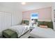 Spacious bedroom with two twin beds, green velvet benches, and a large window at 159 Golden Noble St, Kissimmee, FL 34747