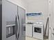 Laundry room with washer, dryer, refrigerator, and ample shelving at 159 Golden Noble St, Kissimmee, FL 34747