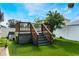 Elevated wooden deck with stairs, hot tub, and artificial turf at 1812 Hudson Ct, Kissimmee, FL 34759