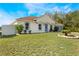 Tan house with gray garage door and a nicely landscaped front yard at 1812 Hudson Ct, Kissimmee, FL 34759