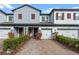 Two-story townhome with gray siding, red shutters, and a brick driveway at 308 Rustic Loop, Sanford, FL 32771