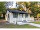 Newly renovated home with white exterior, black accents, and a small porch at 3149 W Washington St, Orlando, FL 32805