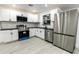 Modern kitchen with white cabinets, stainless steel appliances, and a black countertop at 3149 W Washington St, Orlando, FL 32805