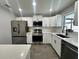 Modern kitchen with white cabinets, stainless steel appliances, and quartz countertops at 3522 E Kaley Ave, Orlando, FL 32806
