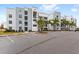 Modern apartment building with ample parking and palm trees at 4721 Clock Tower Dr # 204, Kissimmee, FL 34746