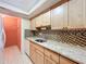Kitchen with light wood cabinets, granite counters, and tile backsplash at 505 Polaris Loop # 107, Casselberry, FL 32707