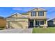 Two-story house with beige siding, stone accents, and a two-car garage at 5344 Peach Blossom Blvd, Port Orange, FL 32128