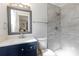 Updated bathroom with a walk-in shower and navy vanity at 5851 Edouard St, Oviedo, FL 32765