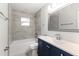 Updated bathroom with a tub and navy vanity at 5851 Edouard St, Oviedo, FL 32765