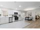 Modern kitchen with white cabinets, quartz countertops, and stainless steel appliances at 5851 Edouard St, Oviedo, FL 32765