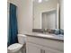 Clean and modern bathroom with white vanity, gray countertop, and blue shower curtain at 8942 Cabot Cliffs Dr, Davenport, FL 33896