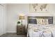 Close-up view of the bedroom, highlighting the bed, nightstand, and compass-themed decor at 8942 Cabot Cliffs Dr, Davenport, FL 33896