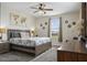 Large bedroom with a king-size bed, ceiling fan, and world map wall decor at 8942 Cabot Cliffs Dr, Davenport, FL 33896