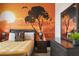 Close-up of a bedroom with a vibrant sunset mural and dark wood furniture at 8942 Cabot Cliffs Dr, Davenport, FL 33896