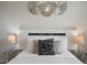 Modern bedroom with white furniture, decorative wall art, and matching nightstands at 8942 Cabot Cliffs Dr, Davenport, FL 33896